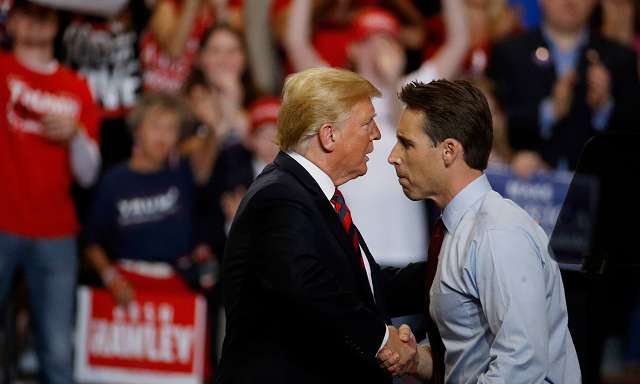 Pres. Trump shakes hands with Senator Josh Hawley on stage of rally.