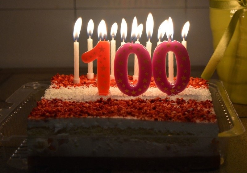 Red and White striped cake with 100 candles.