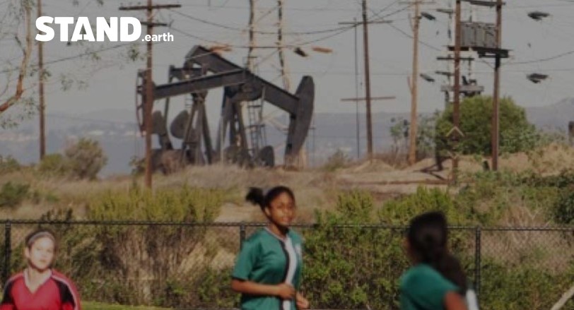 Girl's PE next to oil pump jacks.