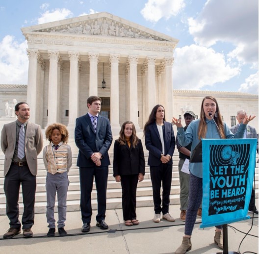 Indigenous youth standing in front of Justice building