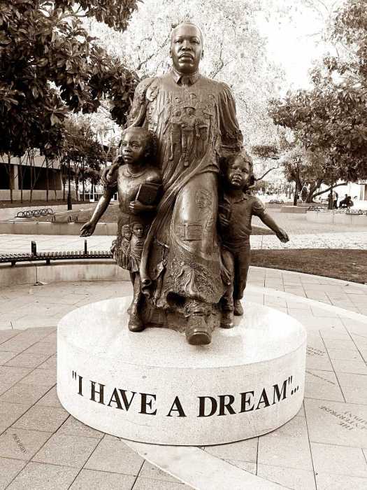 Bronze statue of MLK sheltering, and leading two young children.