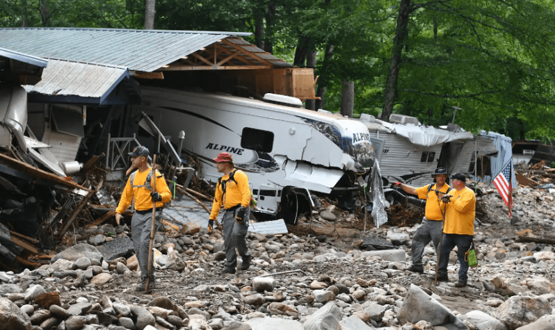 Rescue workers looking at crushed trailers after Hurricane Fred.
