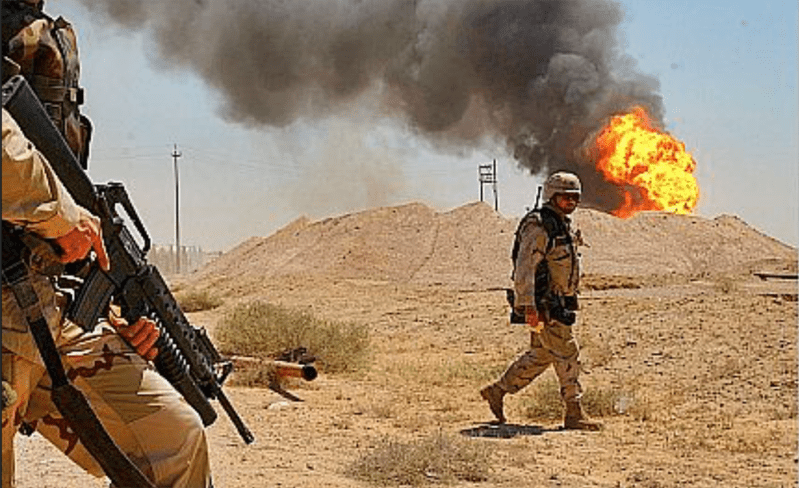Soldiers patrol a polluting wartime fire 