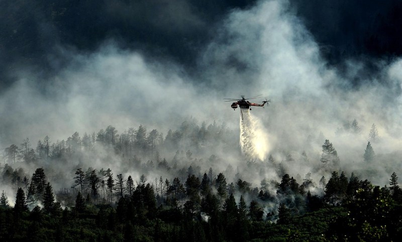 Helicopter dropping water on a fire.